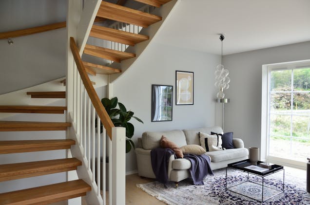 a white couch in a small room to the side of a staircase